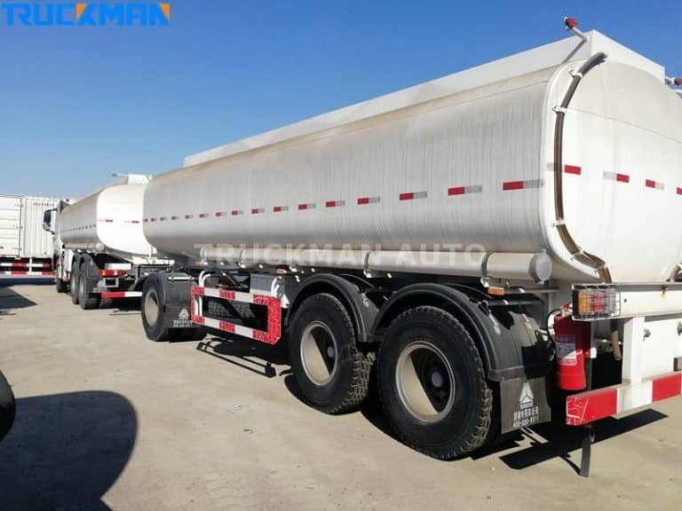 Rear view of a silver chemical tanker trailer with safety valves, affiliated with Truckman Auto