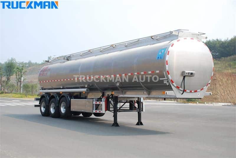 Polished aluminum powder cement tanker trailer on a testing track
