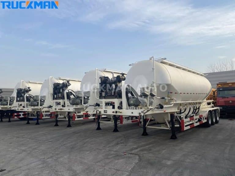Fleet of white cement tanker trailers with mixing equipment, ready for transport by Truckman Auto