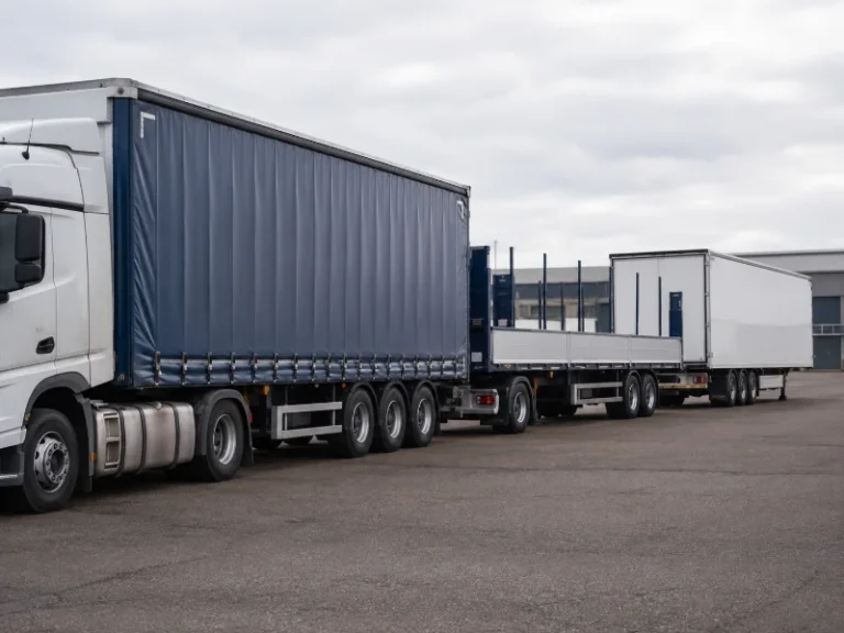 Row of semi trailers parked in a distribution yard under clear daylight